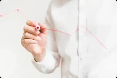 /images/aboutUs/businessperson-s-hand-preparing-red-graph-glass-board 1.webp